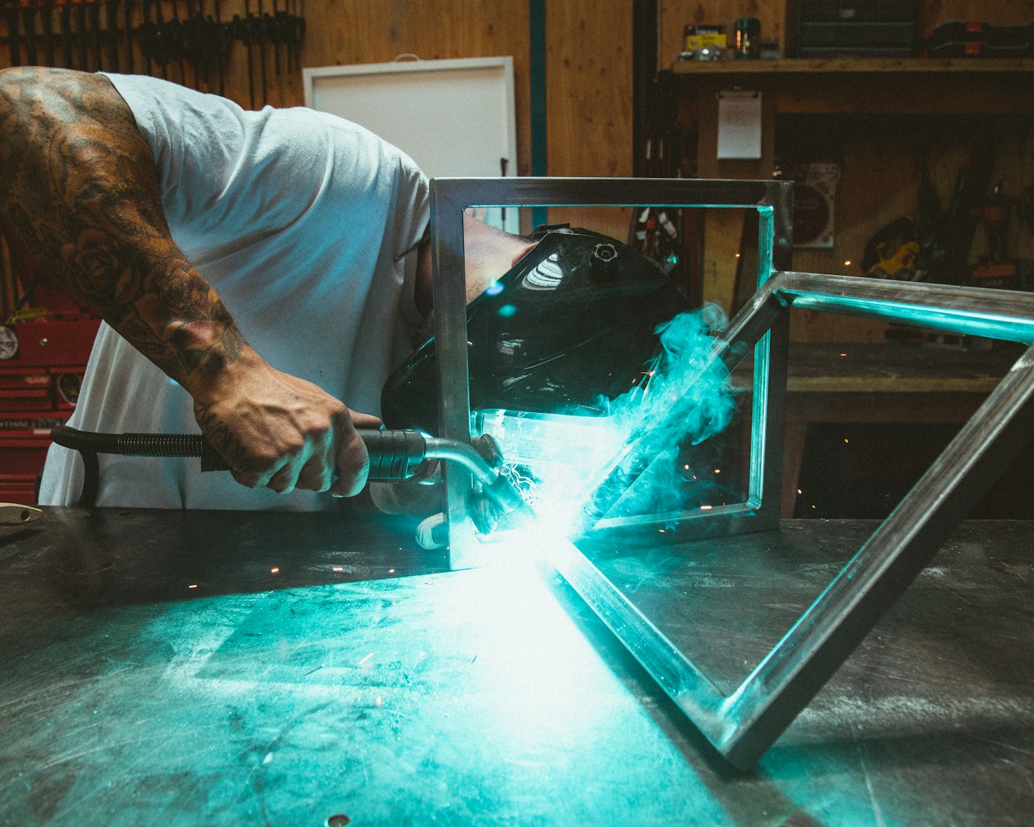 Photo by Dane Deaner man welding two rectangular gray metal frames